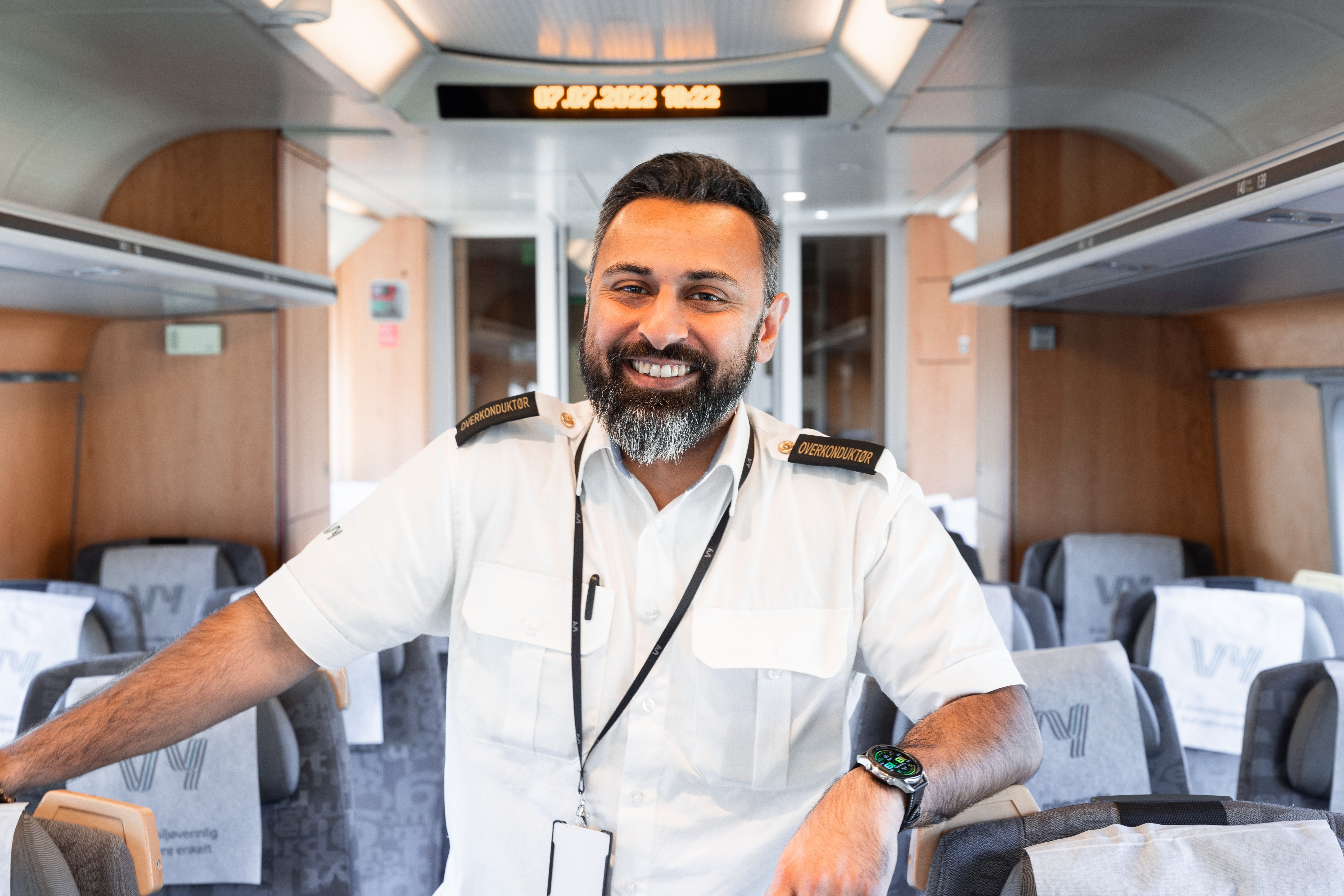 Chief conductor Ali stands in the aisle of the train and smiles