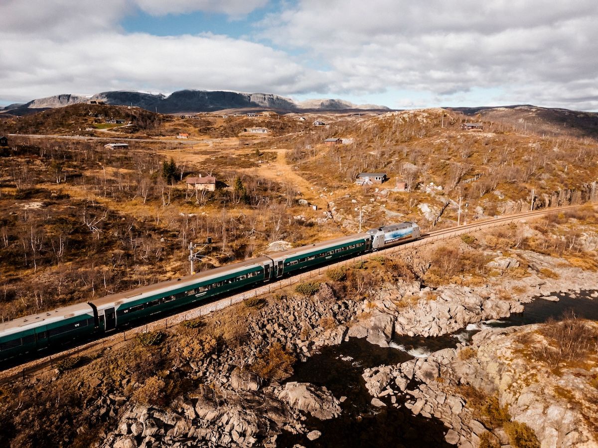 Train driving through autumnal mountain landscape