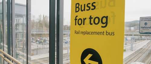 Windows with a yellow poster pointing the way to Rail replacement buses.