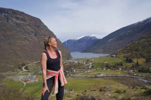 Woman standing in front of a view of mountains and a valley.