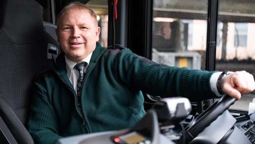 Vidar Engebretsen bak buss rattet smiler til kameraet