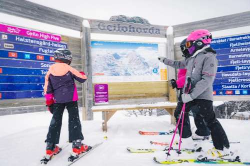 People looking at maps of all the trails the ski resort has.