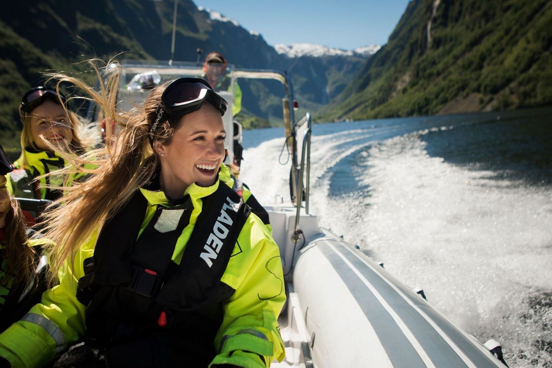 Woman riding in a RIB-boat smiling.