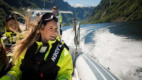 Woman riding in a RIB-boat smiling.