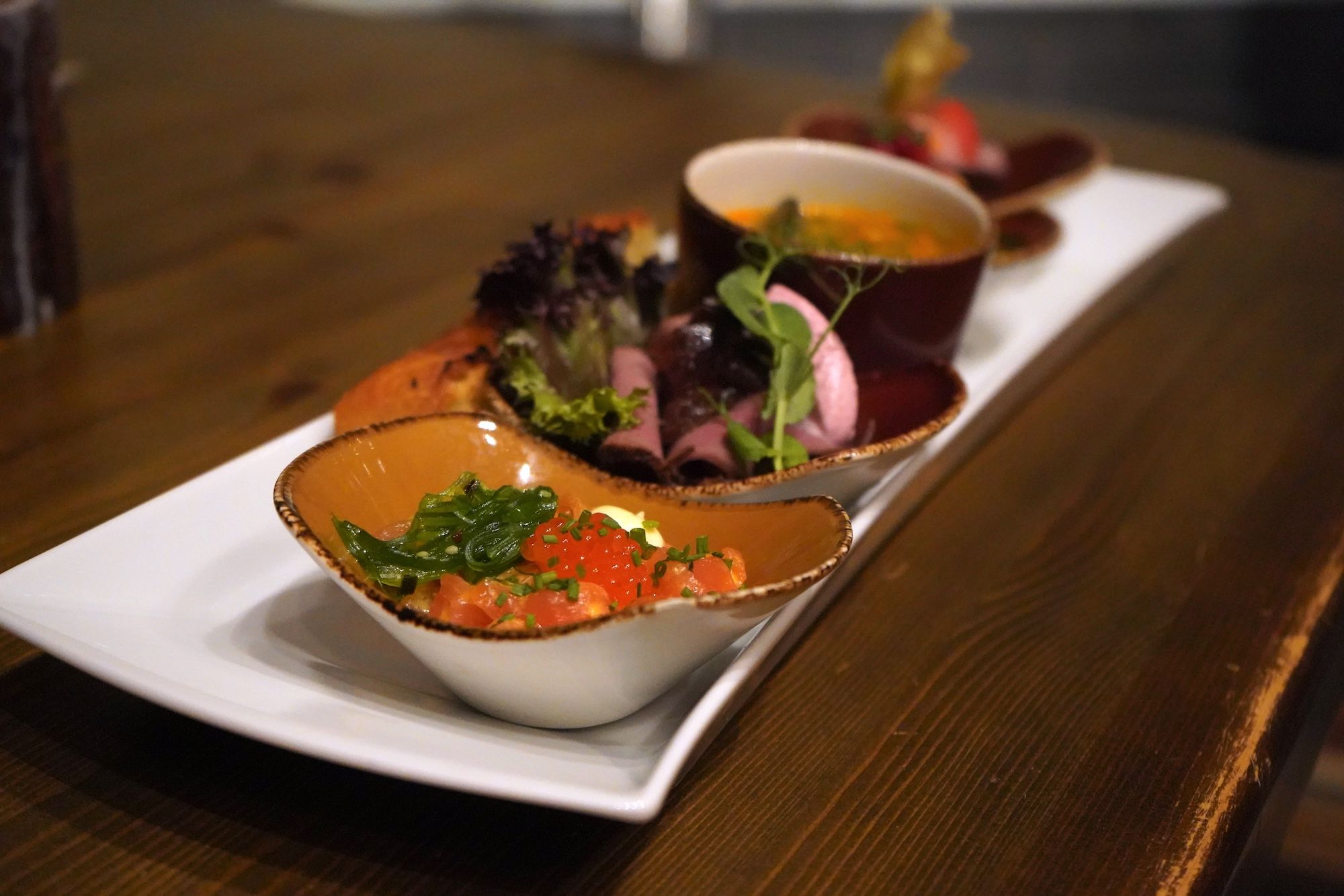 Row of dishes with food.