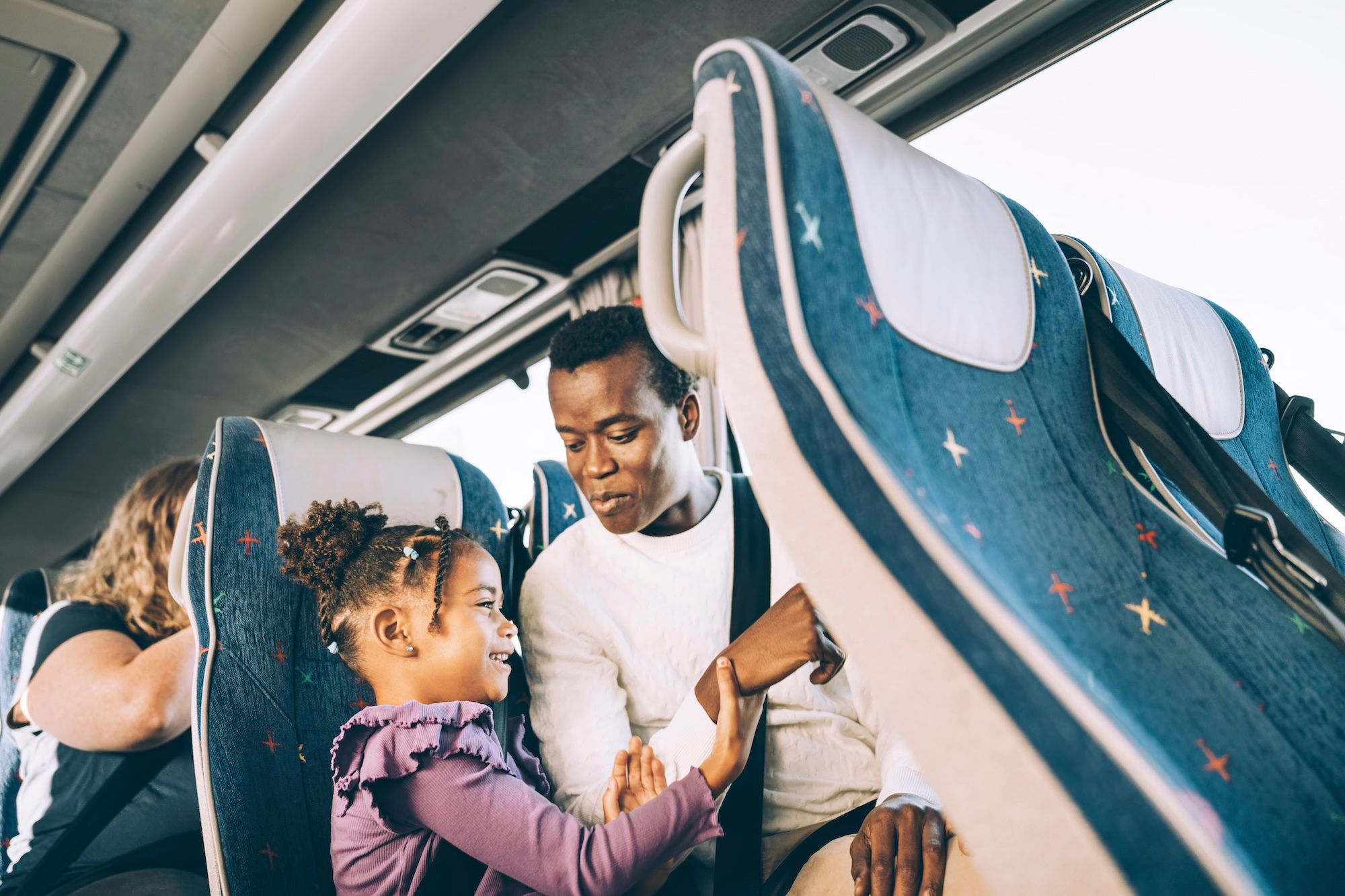 A man and a child sitting together on the bus.