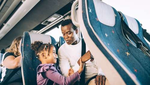 A man and a child sitting together on the bus.