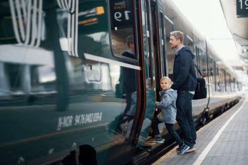 Far og sønn stiger på vy tog