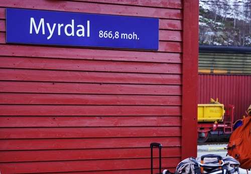 En rød vegg med skilt Myrdal, kofferter i forgrunnen