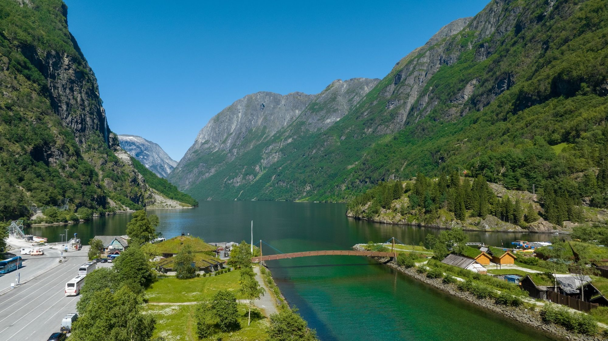 Photo of green nature and mountains with a small village in the valley.