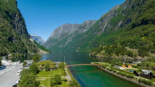 Photo of green nature and mountains with a small village in the valley.