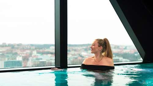 Smilende kvinne som går gjennom en togstasjon.