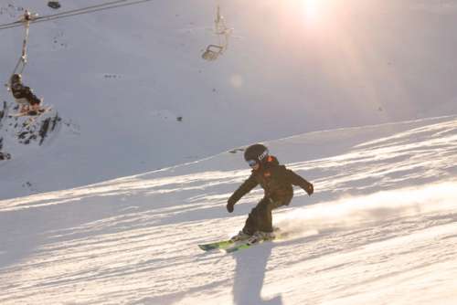 A child skiing down the hill at sunset.