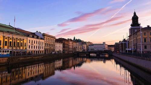 Bygninger på hver side langs kanalen i Gøteborg i solnedgang.