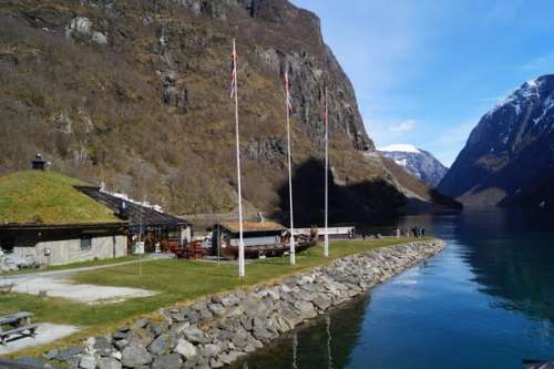 Bygning i bunnen av et fjell ved siden av et vann.