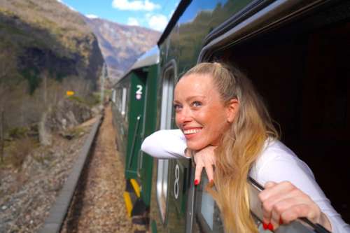 Smiling woman leaning out of a train window.