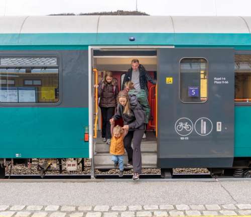 A family stepping out of a train.