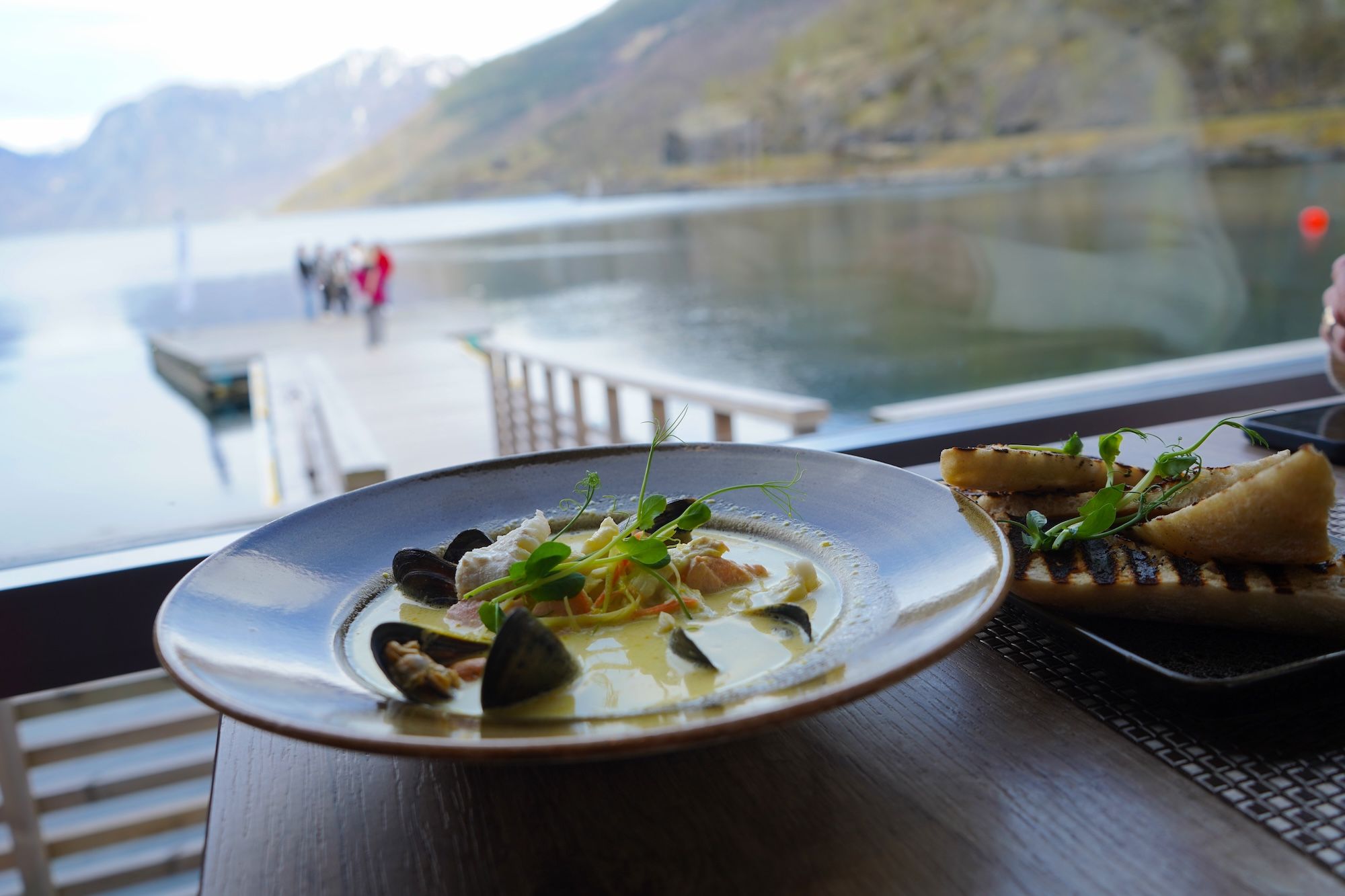 Dish containing mussel soup on a table.