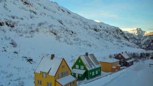 Fargerike hus i Myrdal, omgitt av snødekte fjell.