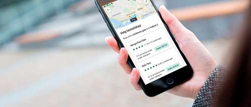 Woman books a taxi in Vy app and looks at offers from various companies