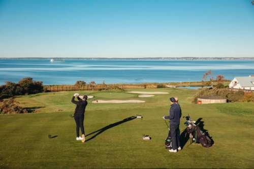 Two people golfing on a green golf course