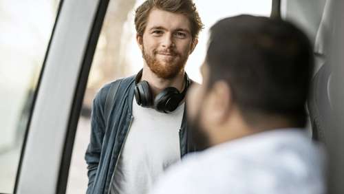 Ung mann går på bussen