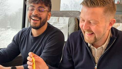 En gruppe kollegaer sitter i sofaer i en kupé og har en workshop