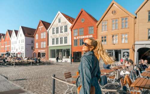 Woman walking on Bryggen in Bergen .