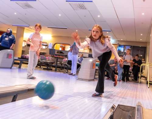 Two children bowling.