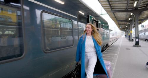 Woman walking at a train station.