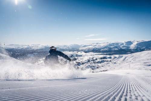 Person skiing down freshly prepared slopes