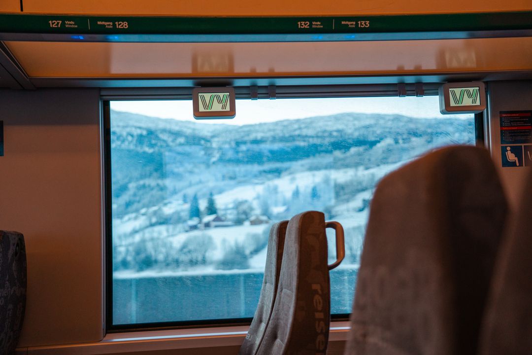 Mann i hvit skjorte som sitter på toget.