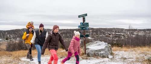 A mother, a father and three children on a hike in nature.