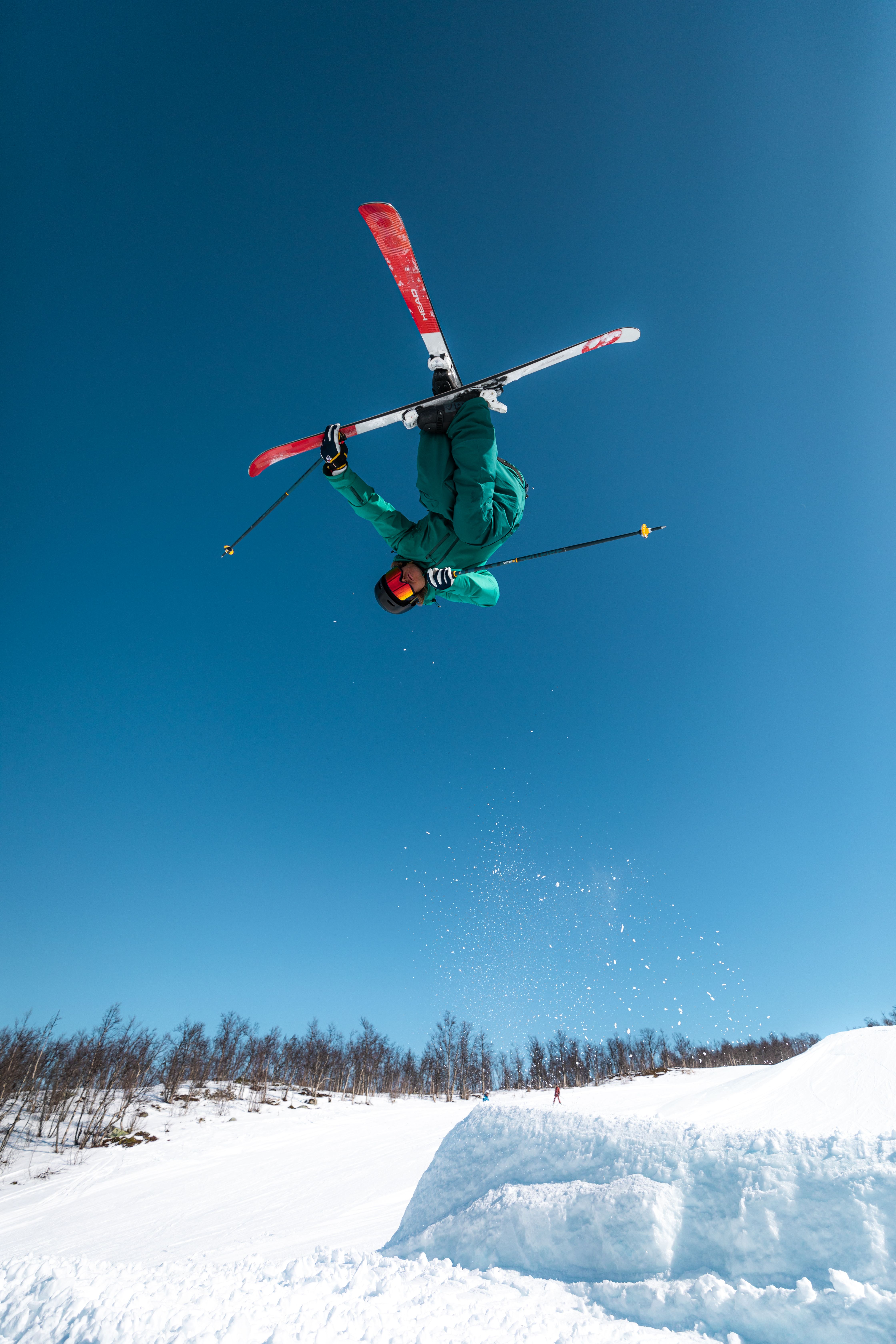 Person performing tricks on skis in the air.