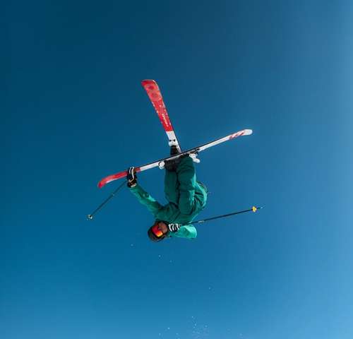 Person performing tricks on skis in the air.