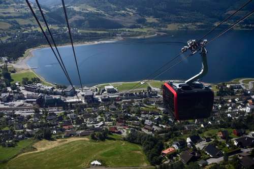 Gondolbanen på Voss svever over byen, med vannet og fjell i bakgrunnen.
