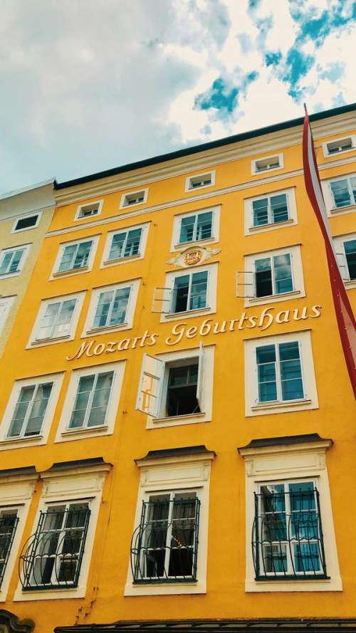 En gul, høy bygning med ordene Mozarts Geburtshaus på.