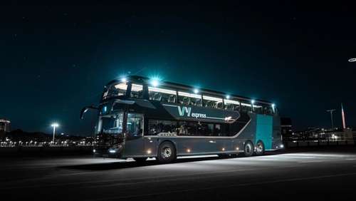 A double decker bus parked during the night.