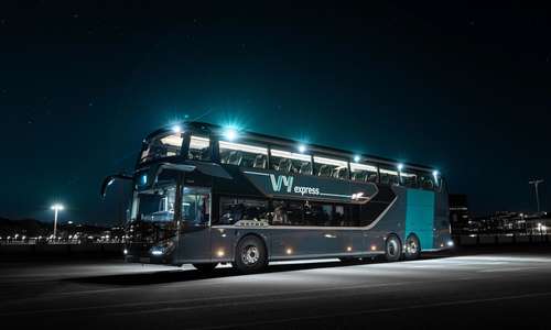 Ein Vy-buss står parkert i mørkret.