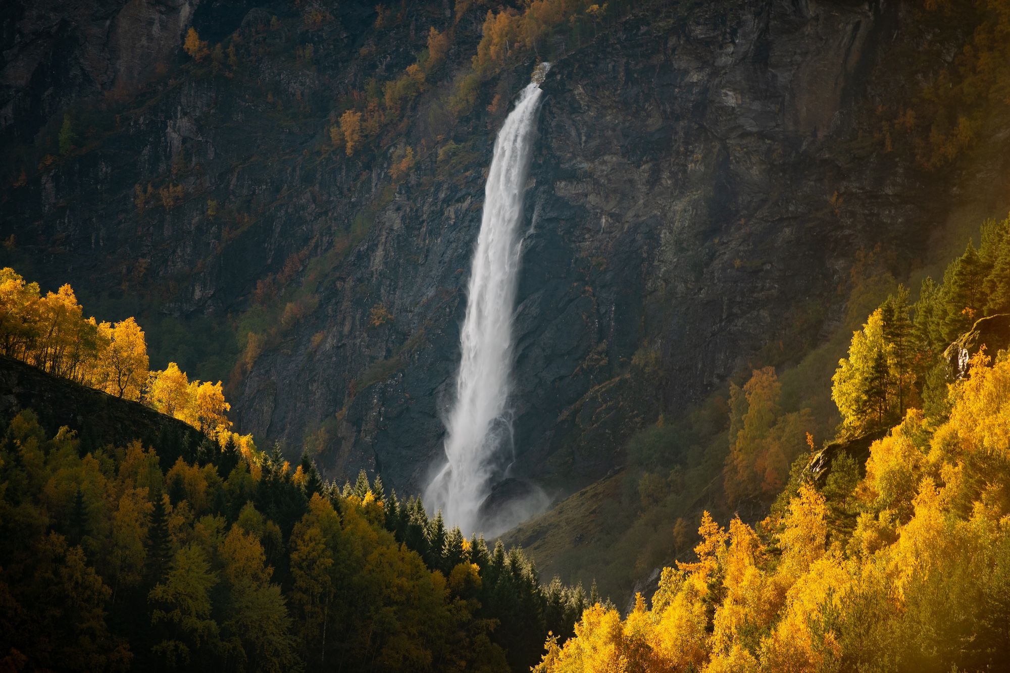 En stor foss faller mellom fjell.