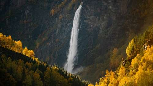 A waterfall falling between mountains.