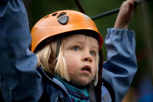 Girl wearing an orange helmet and looking insecure.