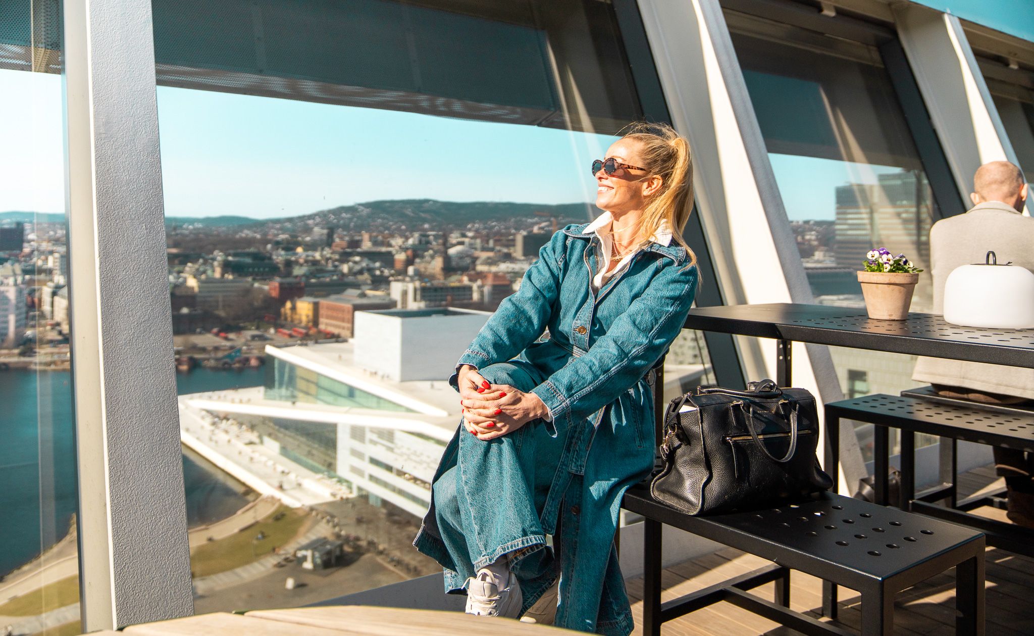 Kvinne nyter utsikten fra takterrasse.