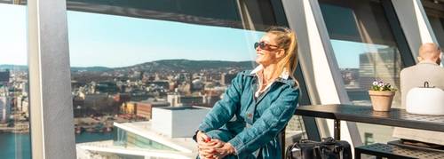 Kvinne nyter utsikten fra takterrasse.