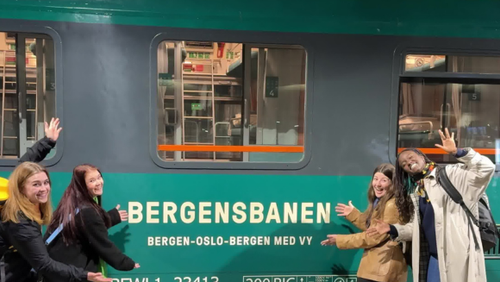 Four girls in front of the green Bergen Line train.