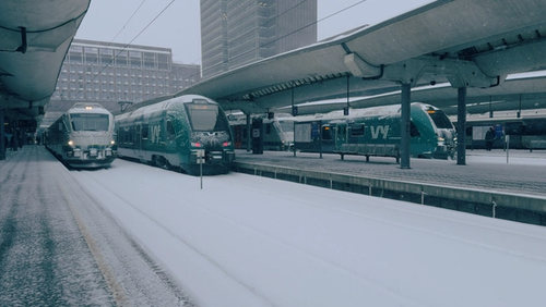 Snøfylt togplatform med tog.