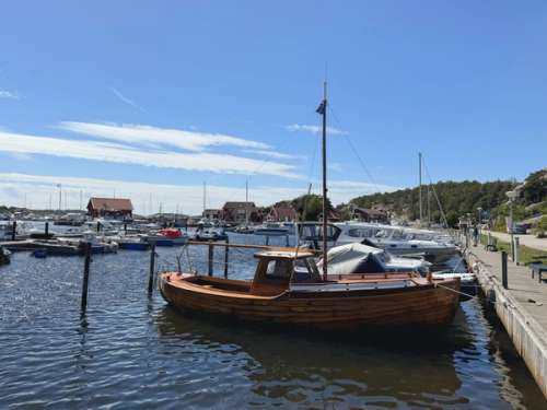 The teeming marina in Skjærhalden with a heritage boat moored to the quayside in stunning weather.