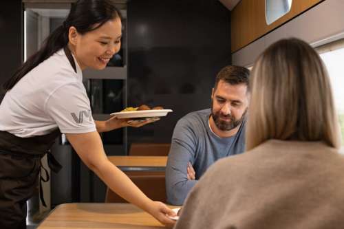 Kaféverten server mat til på i Kafévognen