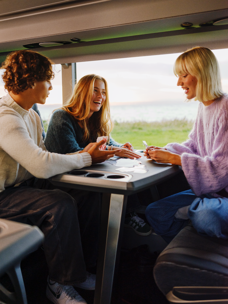 3 personer som sitter på toget sammen.