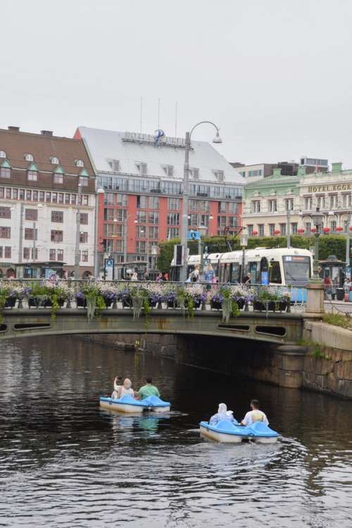 To pedalbåter på en elv på vei under en bro.